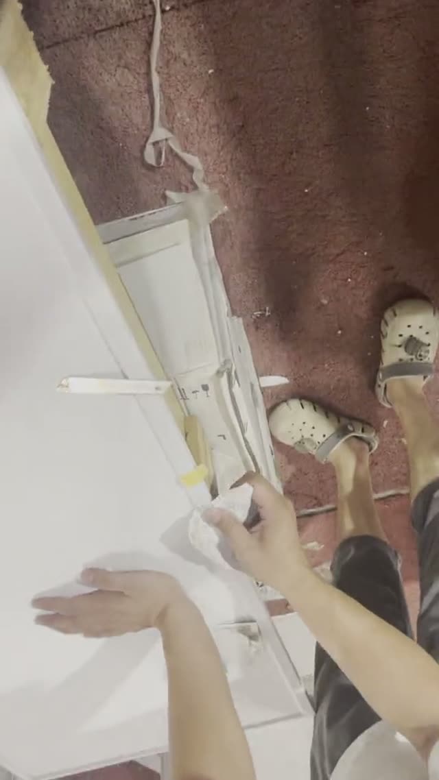 A worker handles a stone piece during workshop activity.