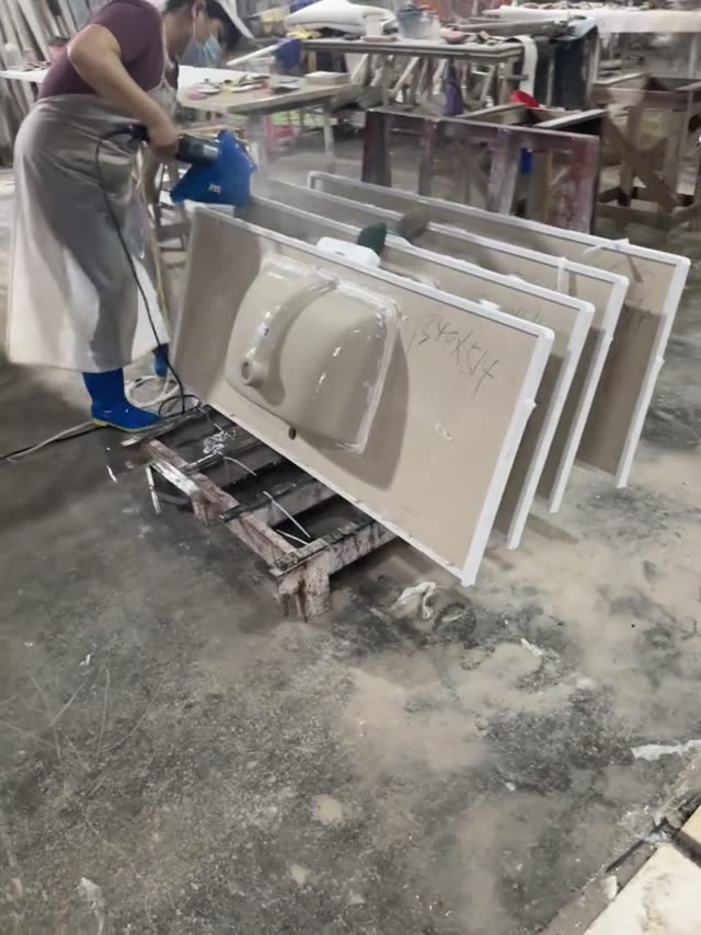 A worker looks over a stone vanity component in the workshop.