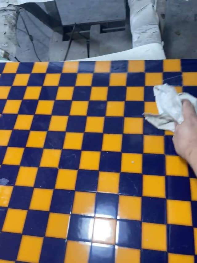 A close view of a marked surface and a hand checking its layout.