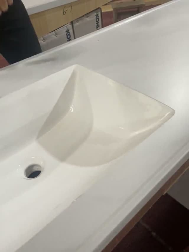 A close-up of a basin form cut into a stone vanity surface.
